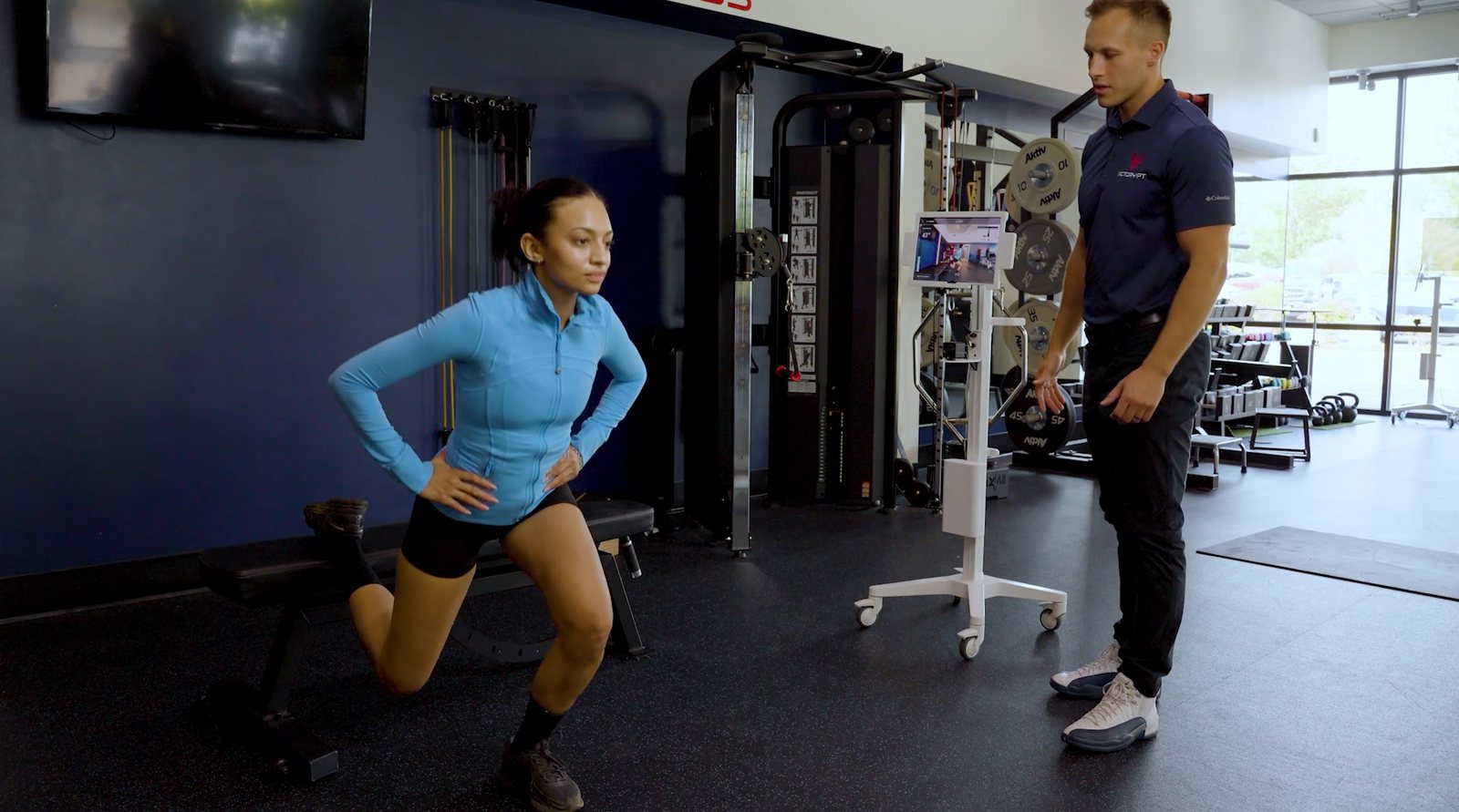 Physical therapist coaching a patient with the PT Copilot kiosk beside them